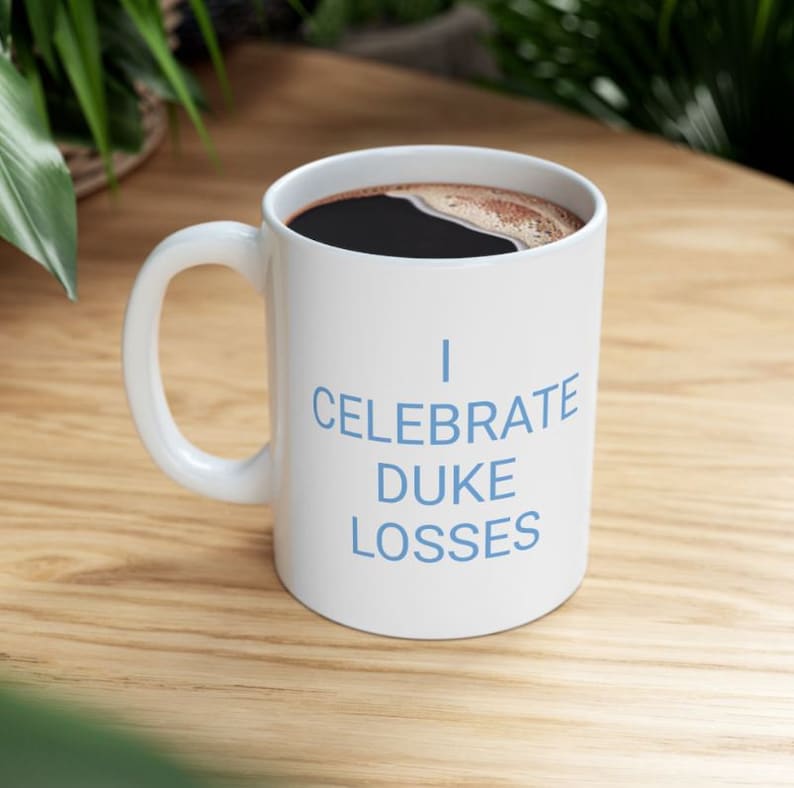 White I Celebrate Duke Losses mug filled with coffee